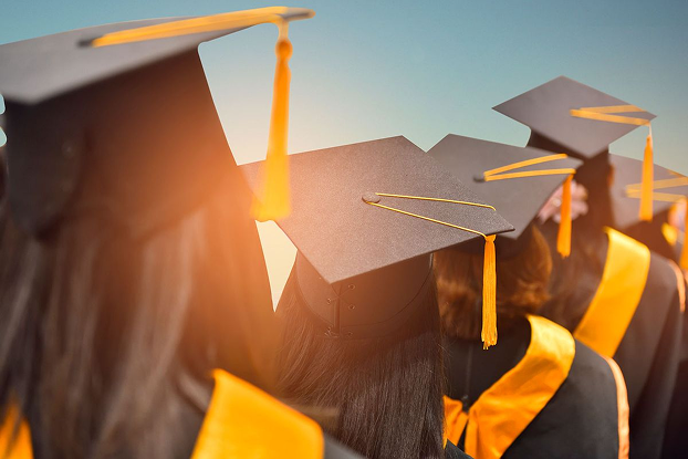 Graduates in caps and gowns at sunset